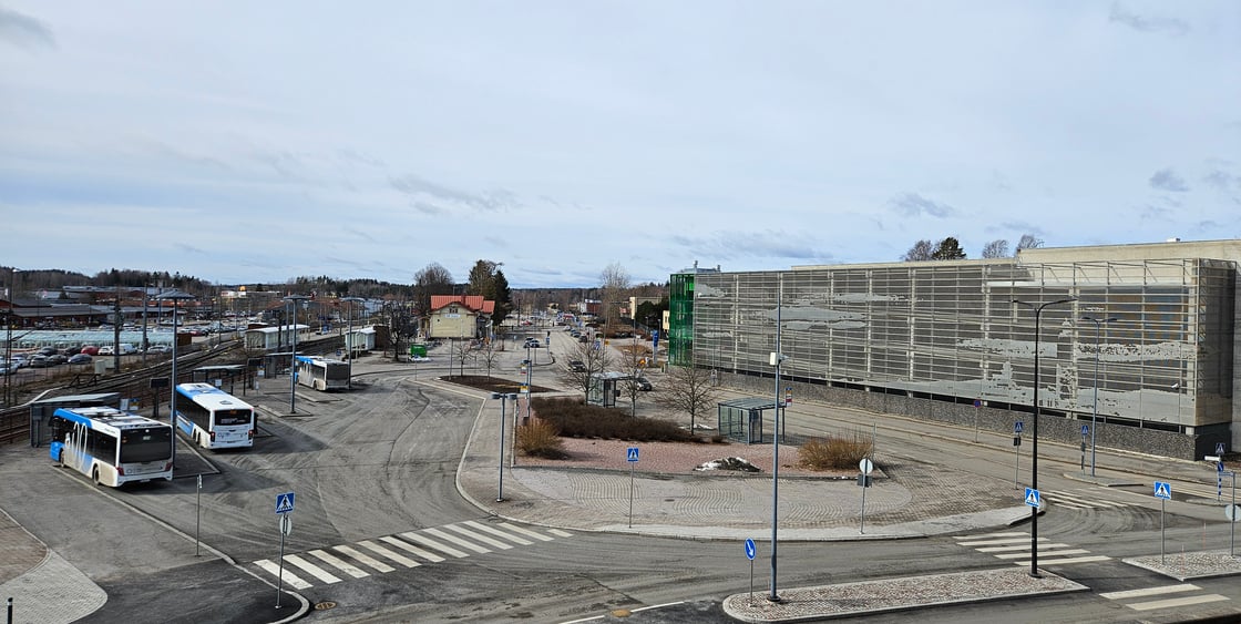 Kuva Kirkkonummen juna- ja bussiasemasta sekä vieressä näkyvästä parkkitalosta.