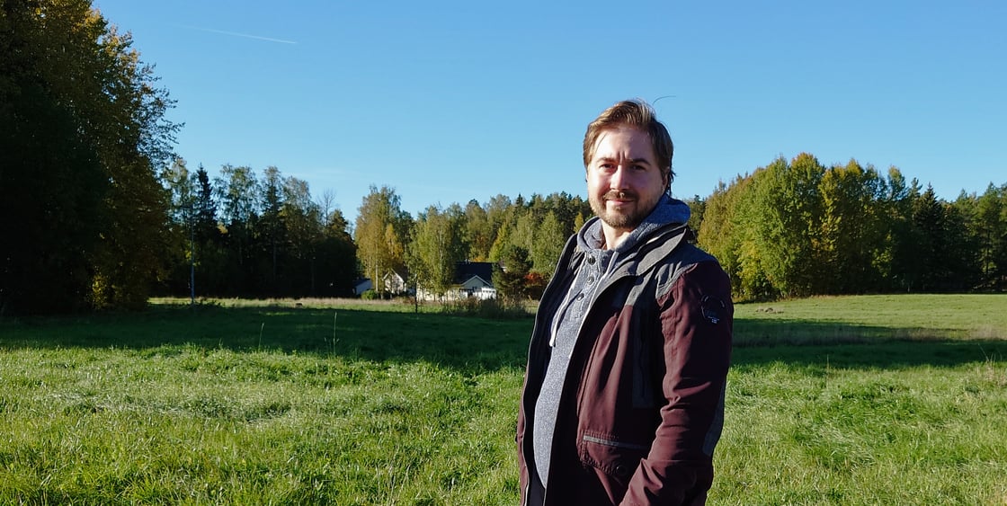 Kuva Lauri Lavannista pellon edustalla. Taaempana taustalla on metsää.