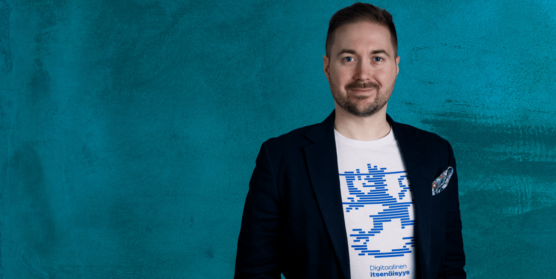 Lauri Lavanti hymyilemässä ja katsomassa kameraan. Päällään hänellä on valkoinen t-paita, jossa lukee Digitaalinen itsenäisyys, jonka yllä on leijonakuvio. Lisäksi pikkutakki. Kuvan ottanut Erkki Laine.
