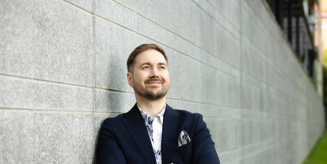 Lauri Lavanti seisoo graniittiseinää vasten kädet ristissä ja katsoo sivulle.