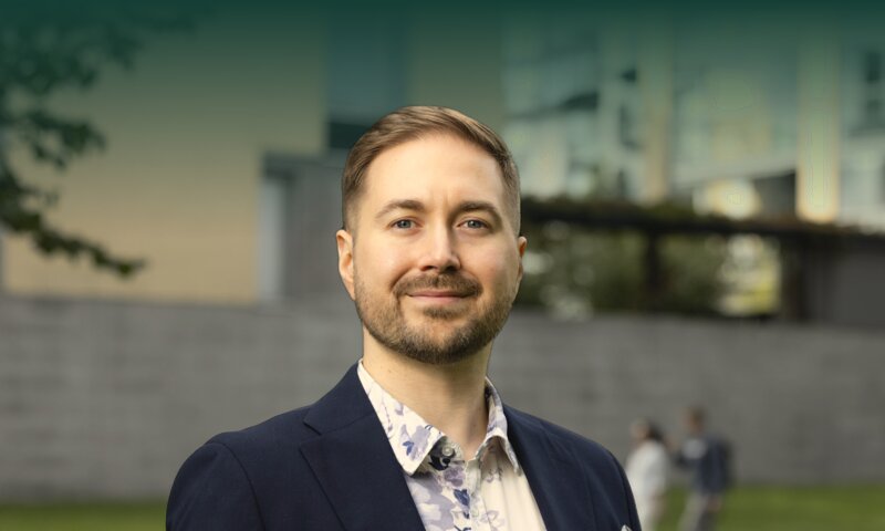 Lauri Lavanti katsoo kameraan puolilähikuvassa kerrostalopihalla, taustalla nurmikkoa ja ohikulkijoita.