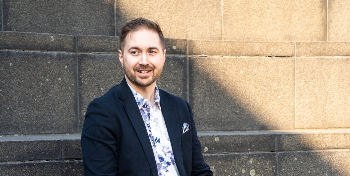 Lauri Lavanti sitter på en utomhustrappa med en bärbar dator i knäet – AI och arbete i en utvecklares vardag